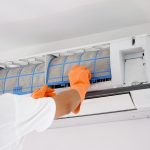 man-cleaning-air-conditioner-dirty-filter-min-scaled.jpg